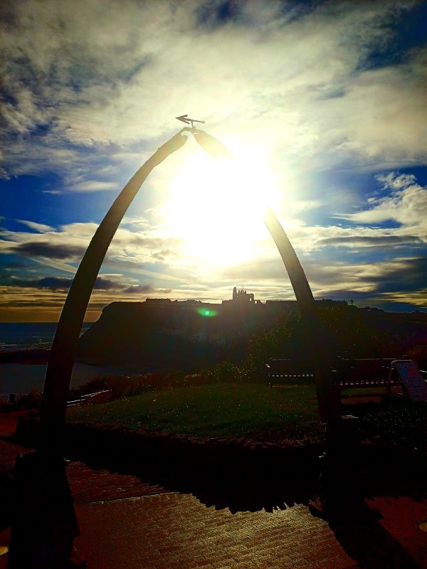 arch with a building in the background in Whitby, Photo Torched Views